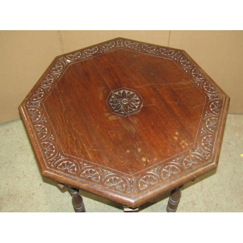 2162 - A Victorian carved oak occasional table of octagonal form with foliate detail raised on turned suppo... 