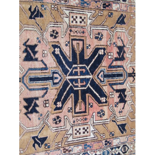 1667 - A North West Persian Heriz Runner with a central row of geometric symbols on a pale brown ground, 30... 