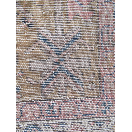 1667 - A North West Persian Heriz Runner with a central row of geometric symbols on a pale brown ground, 30... 