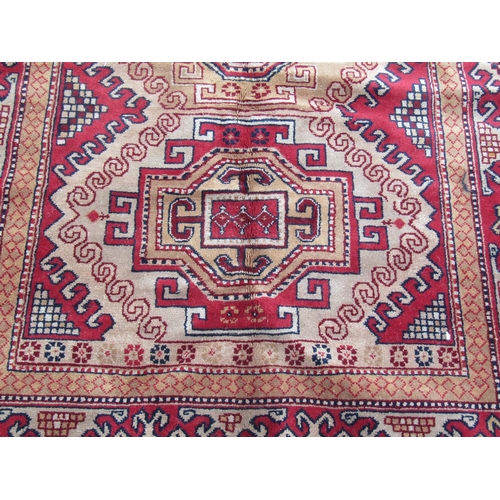 1689 - A Turkish Kazak Rug, with three hooked central medallions on a light brown field 189cm x 127cm, appr... 