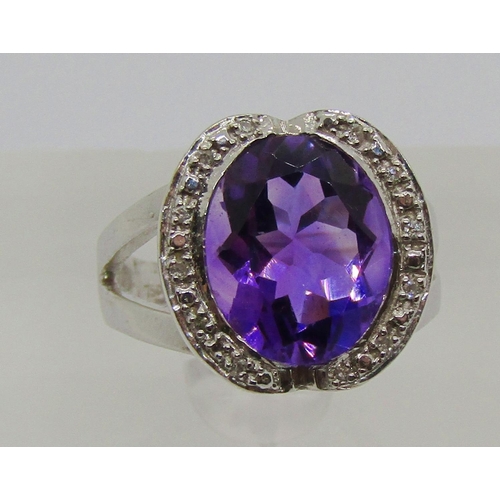 1331 - 18ct white gold oval amethyst and diamond cocktail ring with raised setting, size L/M, 6.2g