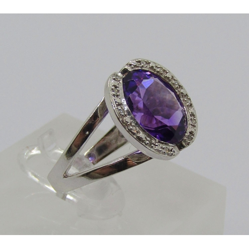 1331 - 18ct white gold oval amethyst and diamond cocktail ring with raised setting, size L/M, 6.2g