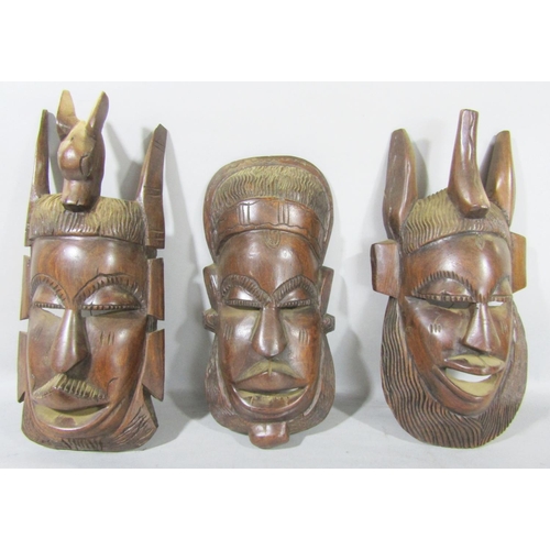 1515 - A beaded Zulu carved mask, three other hardwood carved masks from Africa and a carved wooden figure ... 