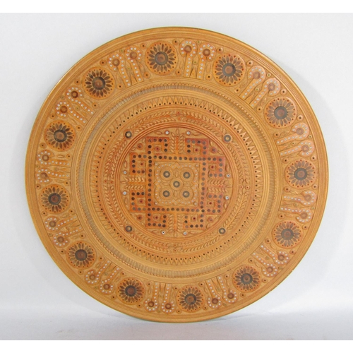 1570 - A German intricately carved carved wooden plate with a repeating all over design. 38.5cm diam