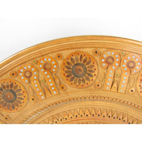 1570 - A German intricately carved carved wooden plate with a repeating all over design. 38.5cm diam