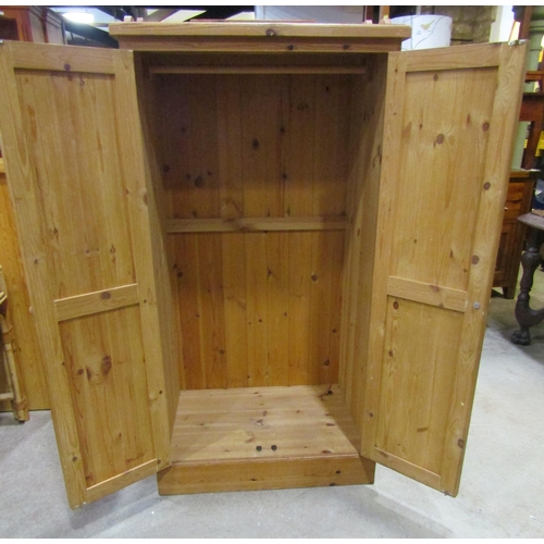 2182 - A stripped pine dwarf wardrobe, with shallow raised and shaped gallery over a pair of full length re... 