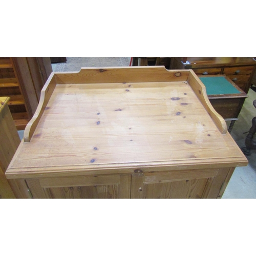 2182 - A stripped pine dwarf wardrobe, with shallow raised and shaped gallery over a pair of full length re... 