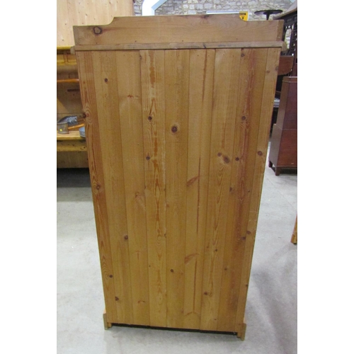 2182 - A stripped pine dwarf wardrobe, with shallow raised and shaped gallery over a pair of full length re... 