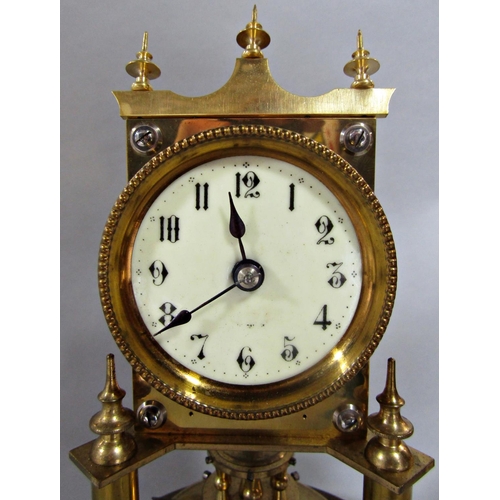 1397 - A brass anniversary clock raised on turned column supports, set beneath a glass dome