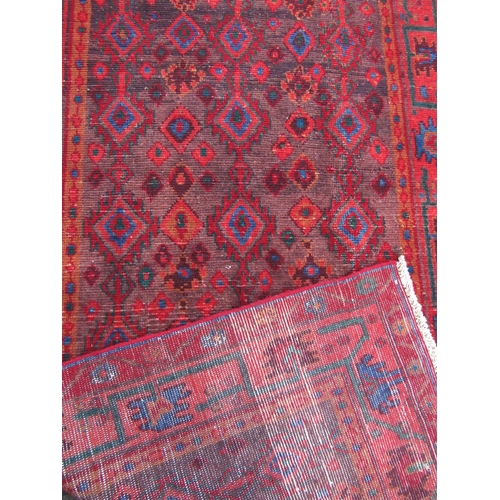 1674 - A Turkish wool carpet with diamond eye pattern on a predominantly red ground.  210cm x 115cm approx.