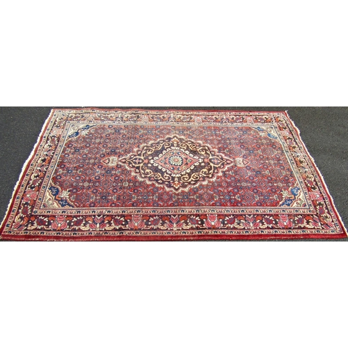 1676 - An old slightly worn Hamadan carpet with a floral medallion on a field of stylised flowers.  220cm x... 