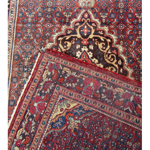 1676 - An old slightly worn Hamadan carpet with a floral medallion on a field of stylised flowers.  220cm x... 