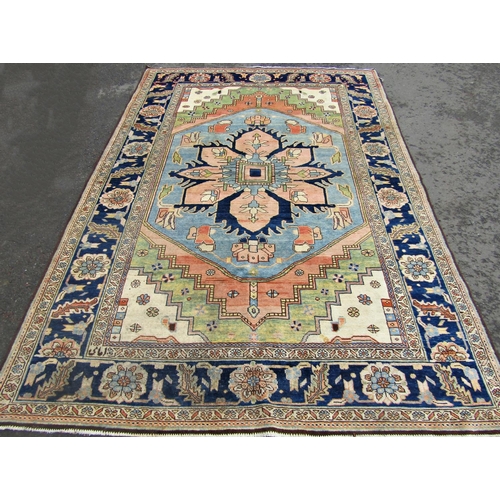 1688 - A Heriz carpet with a broad blue flower shaped central medallion on a pale cream ground, signed in a... 