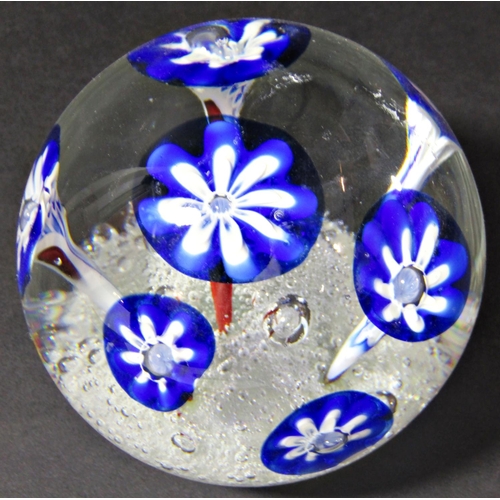 1139 - A single clear glass paperweight with seven stylised blue flowers emerging from a frothy, bubbly exp... 