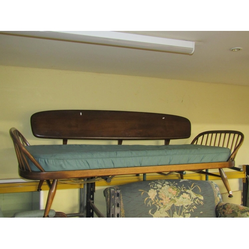 An Ercol day bed in midbrown colour, with detachable elm back on