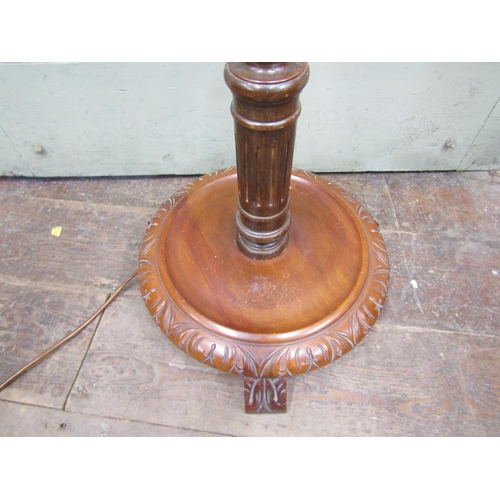 2685 - A lamp standard with turned and tapering column on a circular disc base with carved borders