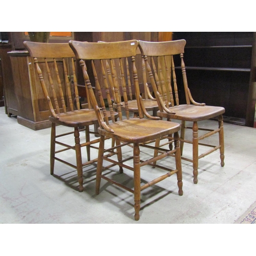 2110 - A set of four turned spindle back kitchen dining chairs principally in ash raised on turned supports... 