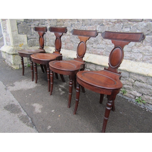 2682 - A set of four good Georgian mahogany hall chairs with oviform seats, slender backs and cameo shaped ... 