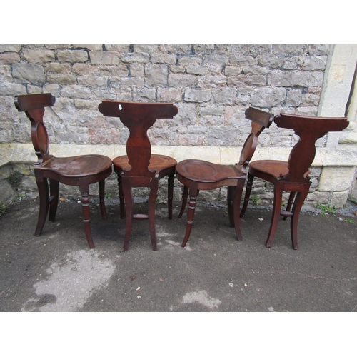 2682 - A set of four good Georgian mahogany hall chairs with oviform seats, slender backs and cameo shaped ... 