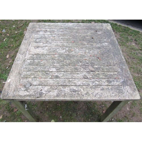 2050A - A weathered teak garden table of square cut form with slatted panelled top, 90 cm square x 75 cm hig... 