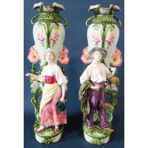 1063 - A substantial pair of art nouveau style majolica vases with floral vine decoration and large standin... 