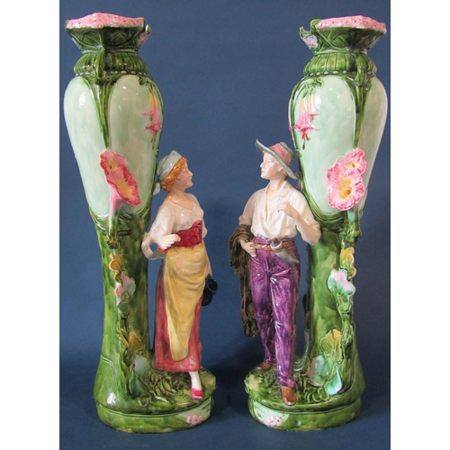 1063 - A substantial pair of art nouveau style majolica vases with floral vine decoration and large standin... 