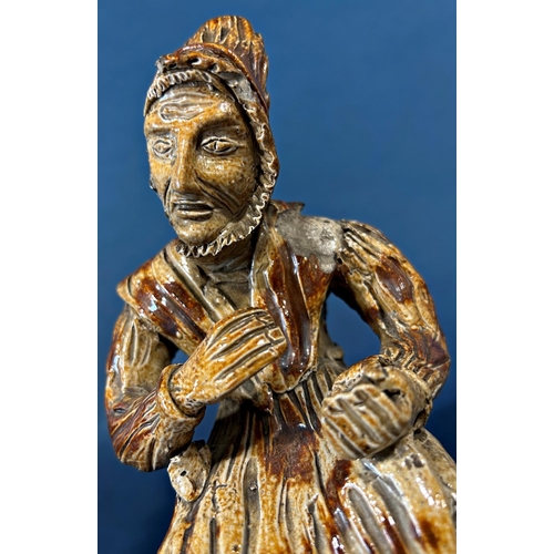 1078 - An early salt glaze model of an old woman taking snuff (af to hat)