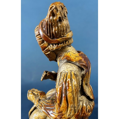 1078 - An early salt glaze model of an old woman taking snuff (af to hat)