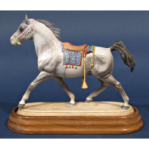 1112 - A Beswick matt glazed figure of an Arab stallion with saddle, set on a polished timber base