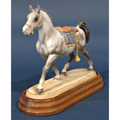 1112 - A Beswick matt glazed figure of an Arab stallion with saddle, set on a polished timber base