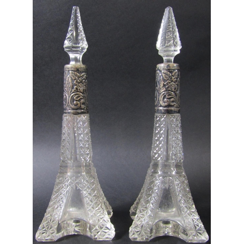 1233 - A pair of Eiffel Tower inspired cut glass scent bottles with silver collars, a silver capped bottle ... 