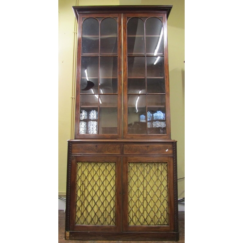 2625 - A Regency mahogany library bookcase, the lower section enclosed by two doors with brass grills and m... 