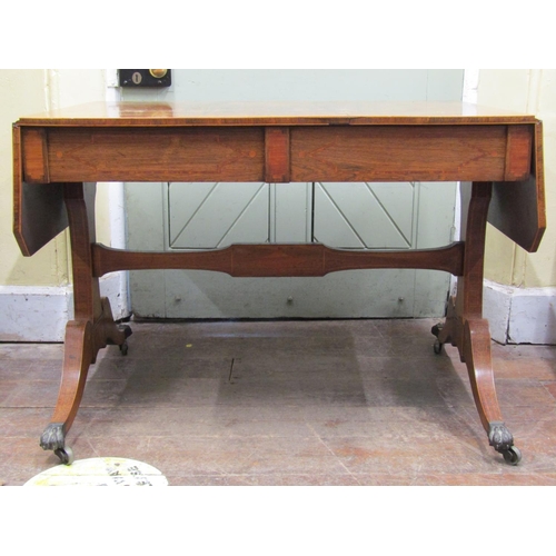 2575 - A Regency rosewood sofa table of usual form, with cross banded borders, raised on an open base with ... 