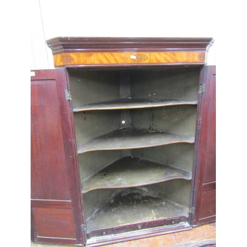 2588 - A Georgian mahogany hanging corner cupboard enclosed by a pair of panelled doors enclosing four shap... 