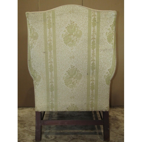 2151 - A Georgian style wing armchair raised on square cut and moulded supports united by stretchers, (for ... 