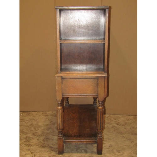 2163 - An early 20th century oak freestanding side cupboard enclosed by a central panelled door, with shelv... 