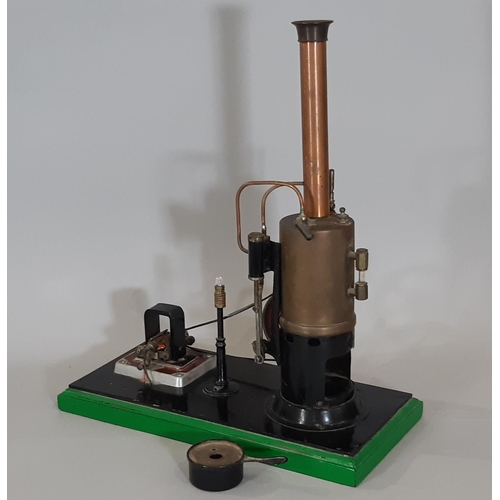 329 - A live steam display layout comprising a vertical steam engine with 7cm/3