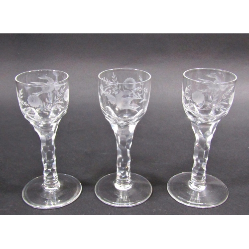 1154 - Three 19th century floral and bird engraved, cut glass wine glasses on faceted stems 14.5cm tall.