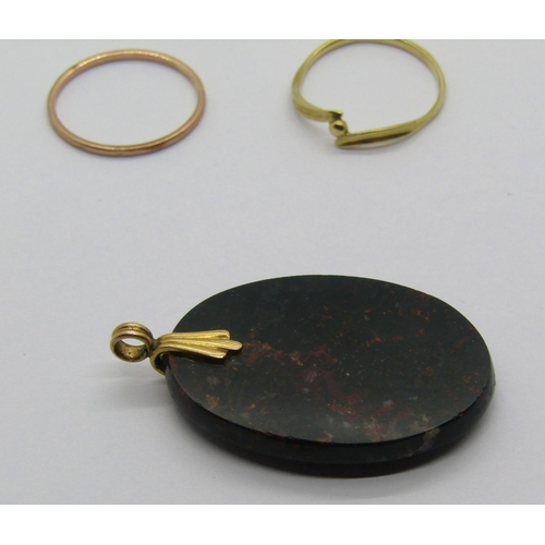 1262 - Group of yellow metal jewellery comprising an oval bloodstone pendant and two rings (3)