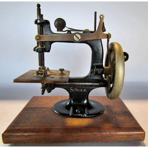 1452 - A miniature Singer Sewing Machine, on a wooden plinth, 20cm high x 19cm wide (inc the plinth)