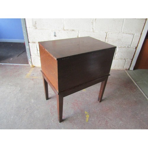 2468 - A vintage oak filing cabinet with rising and divided lid set on square cut supports