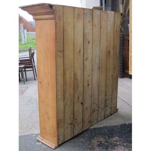 2528 - A stripped and waxed pine cupboard enclosed by two glazed panelled doors, 128cm wide, together with ... 