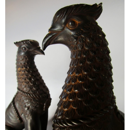 1431 - A pair of wingless Griffins, in a bronze effect finish, raised on slate plinths. 27cm tall