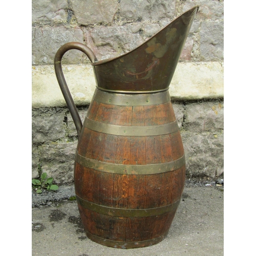 2088 - A large coopered oak brass banded loop handled and lipped jug/pitcher, 65cm high