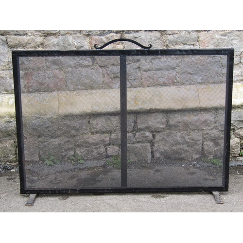 2094A - An iron framed fire guard of rectangular form with wire mesh panel and open simple scroll looped han... 