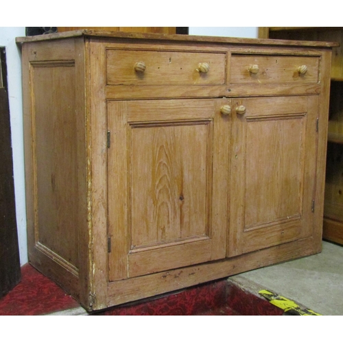 2100 - A 19th century stripped pine kitchen side cupboard enclosed by a pair of moulded panelled doors bene... 