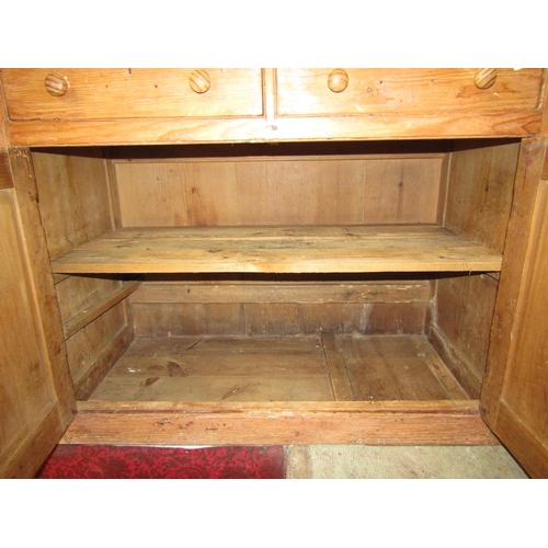 2100 - A 19th century stripped pine kitchen side cupboard enclosed by a pair of moulded panelled doors bene... 