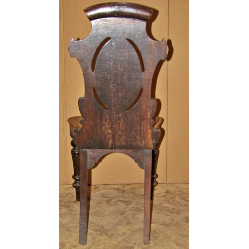 2181 - Victorian oak hall chair with carved and scrolled shield shaped back over a solid seat, raised on tu... 