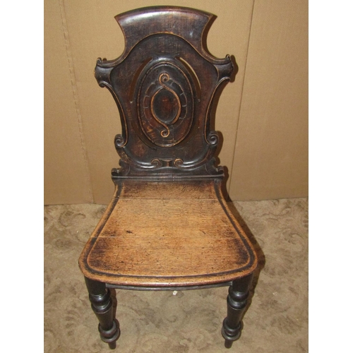 2181 - Victorian oak hall chair with carved and scrolled shield shaped back over a solid seat, raised on tu... 