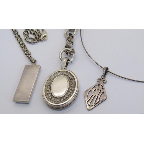 1335 - Three silver pendant necklaces; a Victorian style embossed locket hung from belcher chain, a 1970s i... 